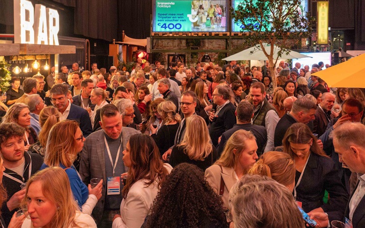 Drukbezochte vloer van Vakantie Festival met bezoekers en commerciële partners