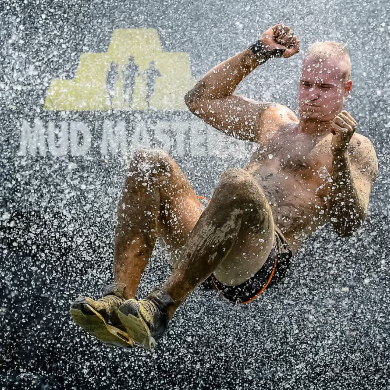 Participant splashing through water at a Mud Masters obstacle